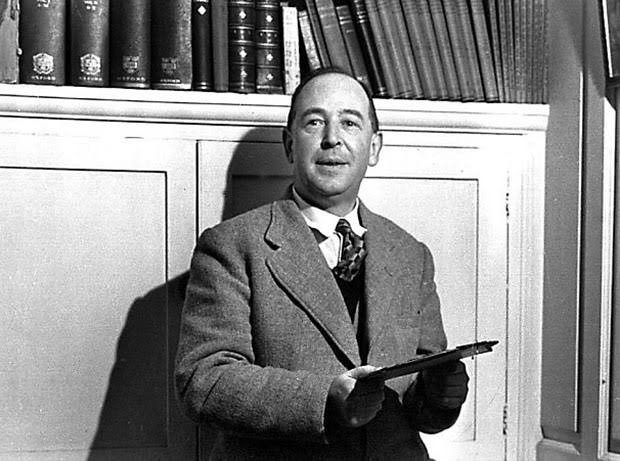 Retrato de C.S. Lewis segurando um livro, diante de sua estante