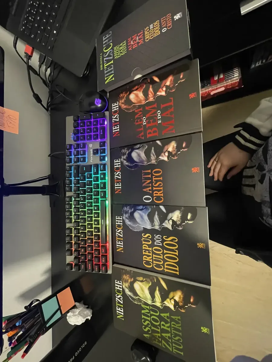 Coleção Nietzsche fotografada sobre uma mesa ao lado de teclado colorido